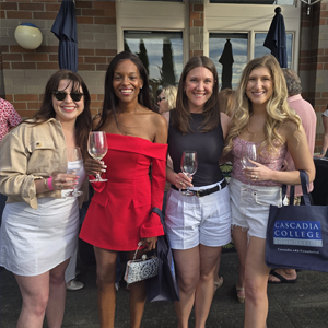four people posing with wine glasses