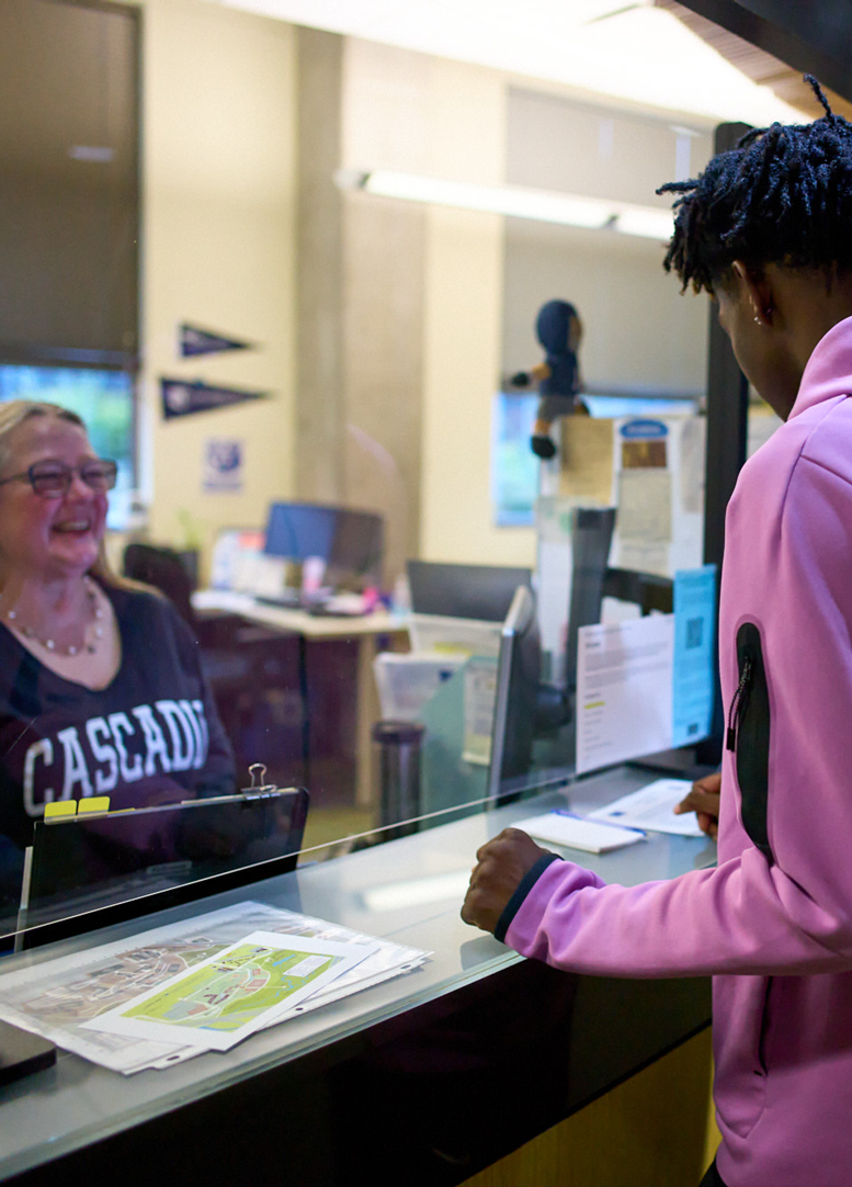 A student at Kodiak Corner engaged in conversation with enrollment service staff. Can I afford to attend