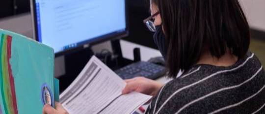 A student reading in front of a computer, demonstrating a focused and studious approach to online learning or research. A student reading in front of a computer, demonstrating a focused and studious approach to online learning or research.