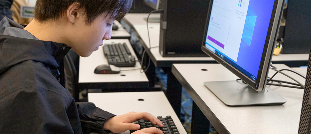 A student reading in front of a computer, demonstrating a focused and studious approach to online learning or research. A student reading in front of a computer, demonstrating a focused and studious approach to online learning or research.