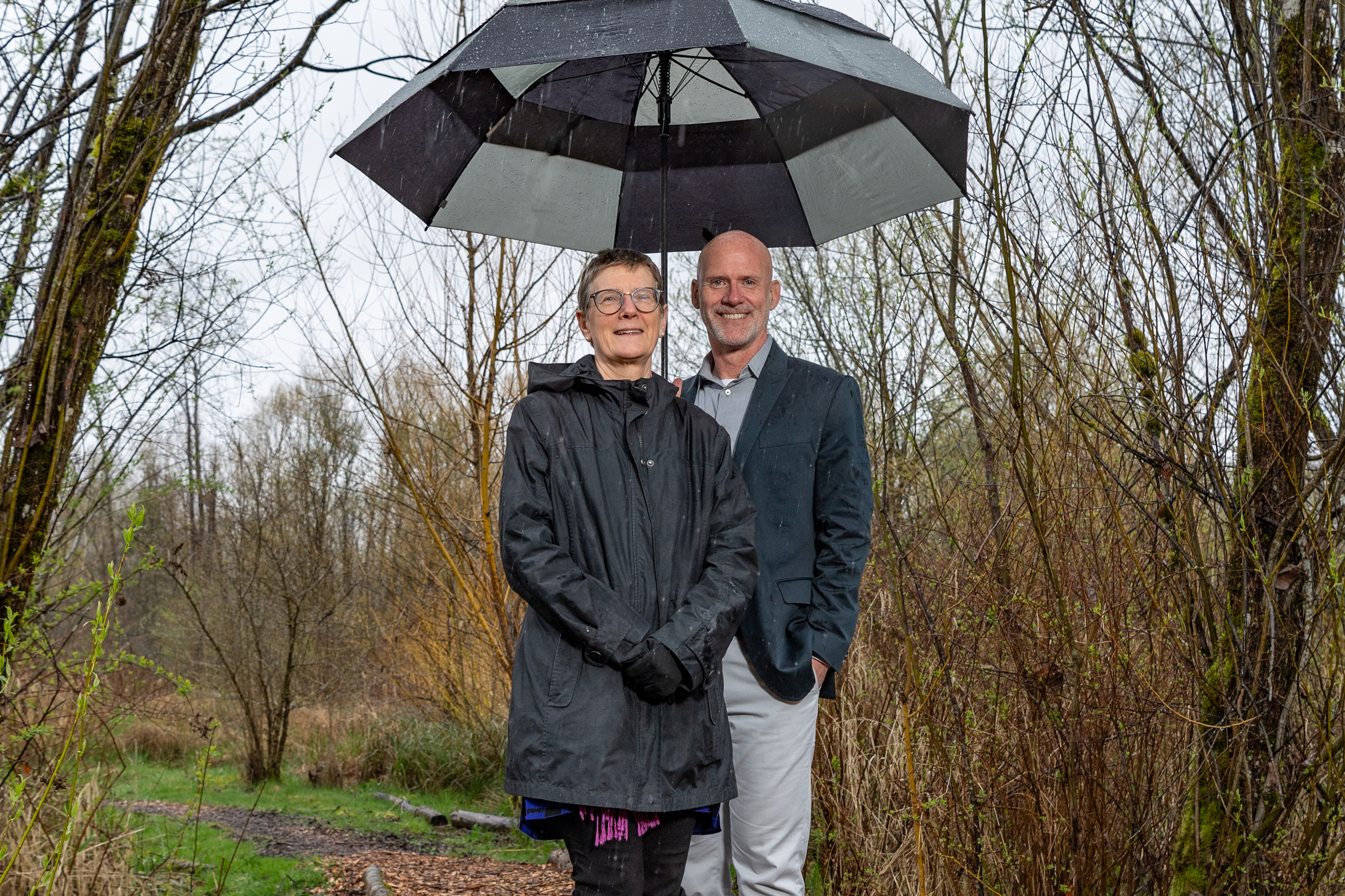 PSBJ Award - Dignitaries President Murray and Chancellor Esterberg under an umbrella in the wetland