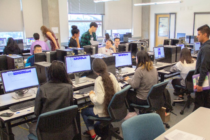 Admitted students seated in front of computers during a classroom session."