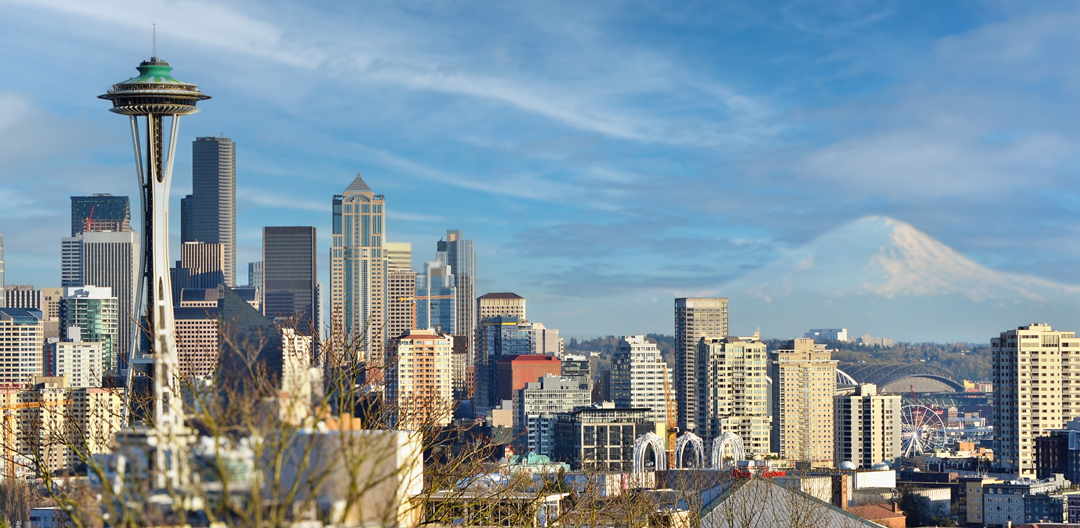 five students in a line holding scholarship award certificates with Cascadia College campus in the background